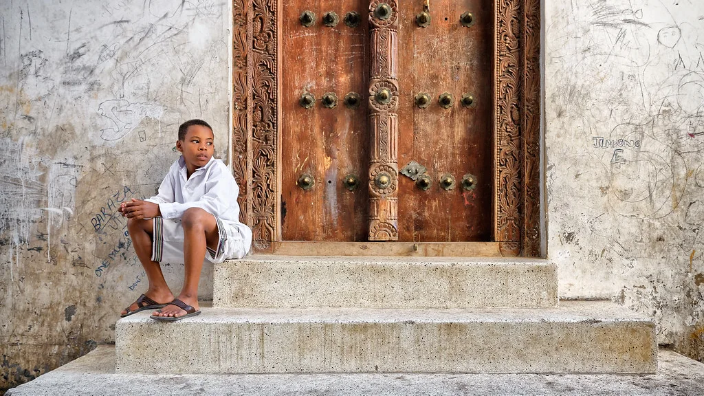 Carved wooden door in a Stone Town alley, Zanzibar